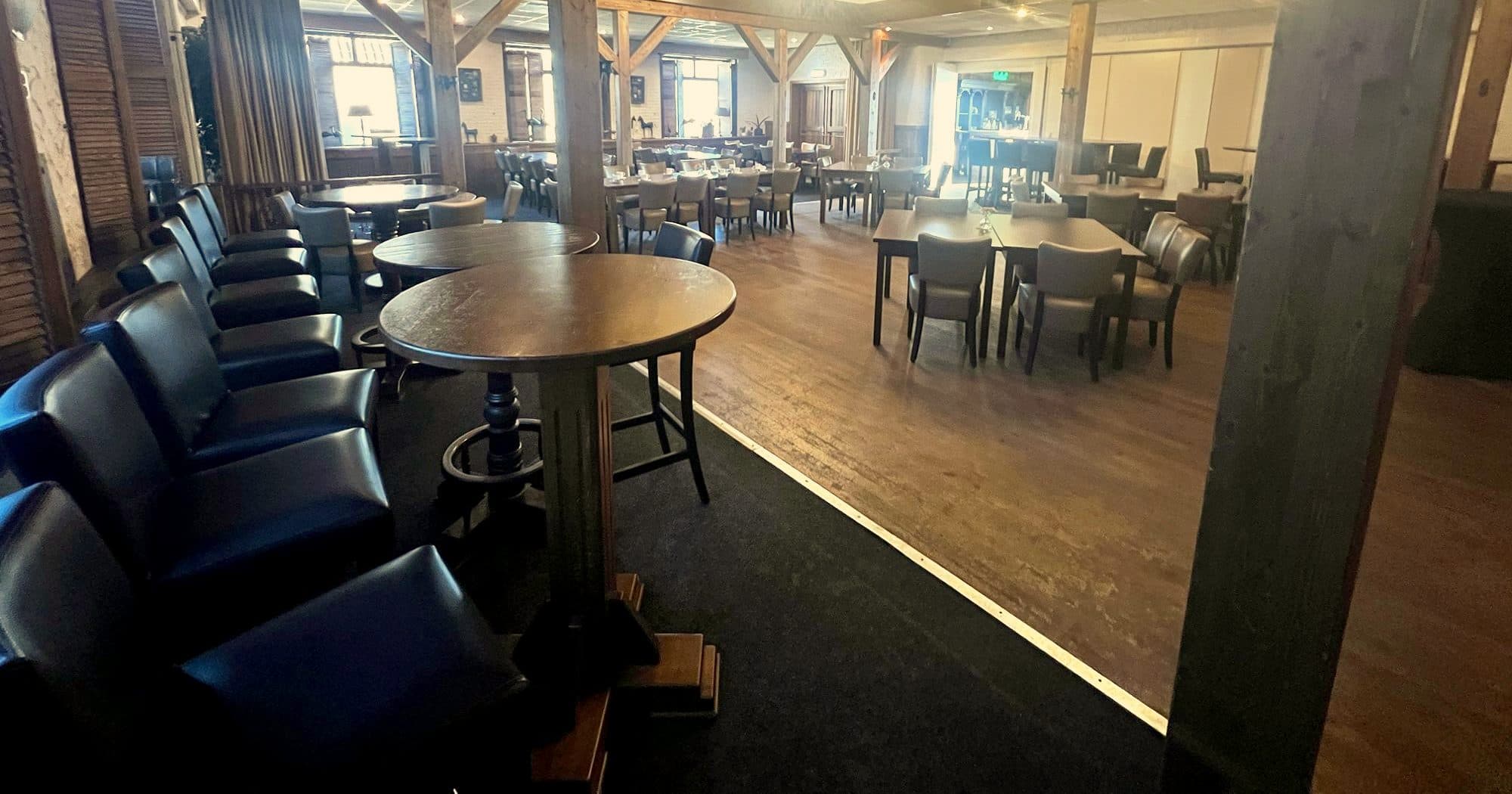De grote zaal van Coens Tapperij met kroonluchters en houten balken
