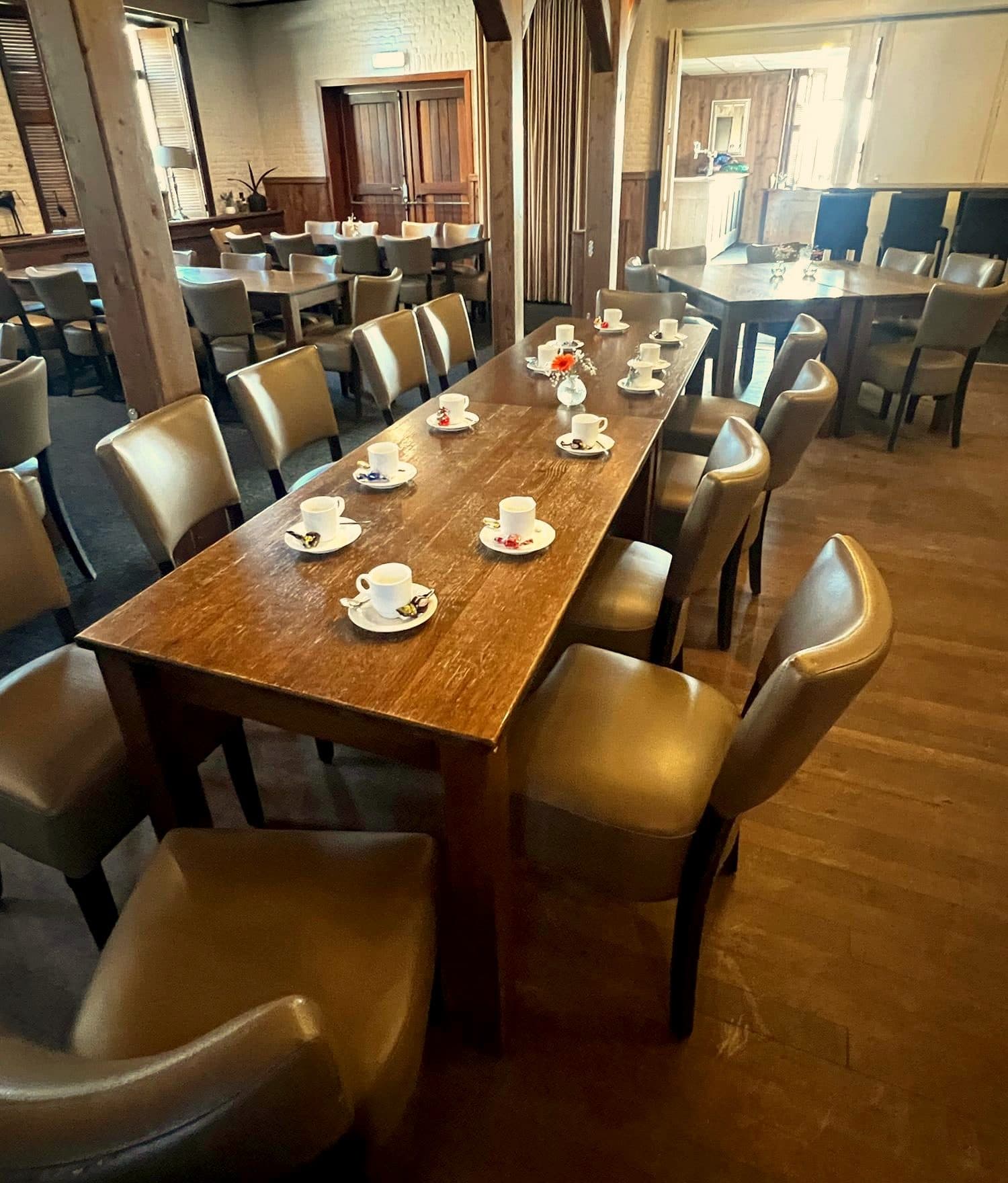 Lange tafel gedekt met koffie in de grote zaal