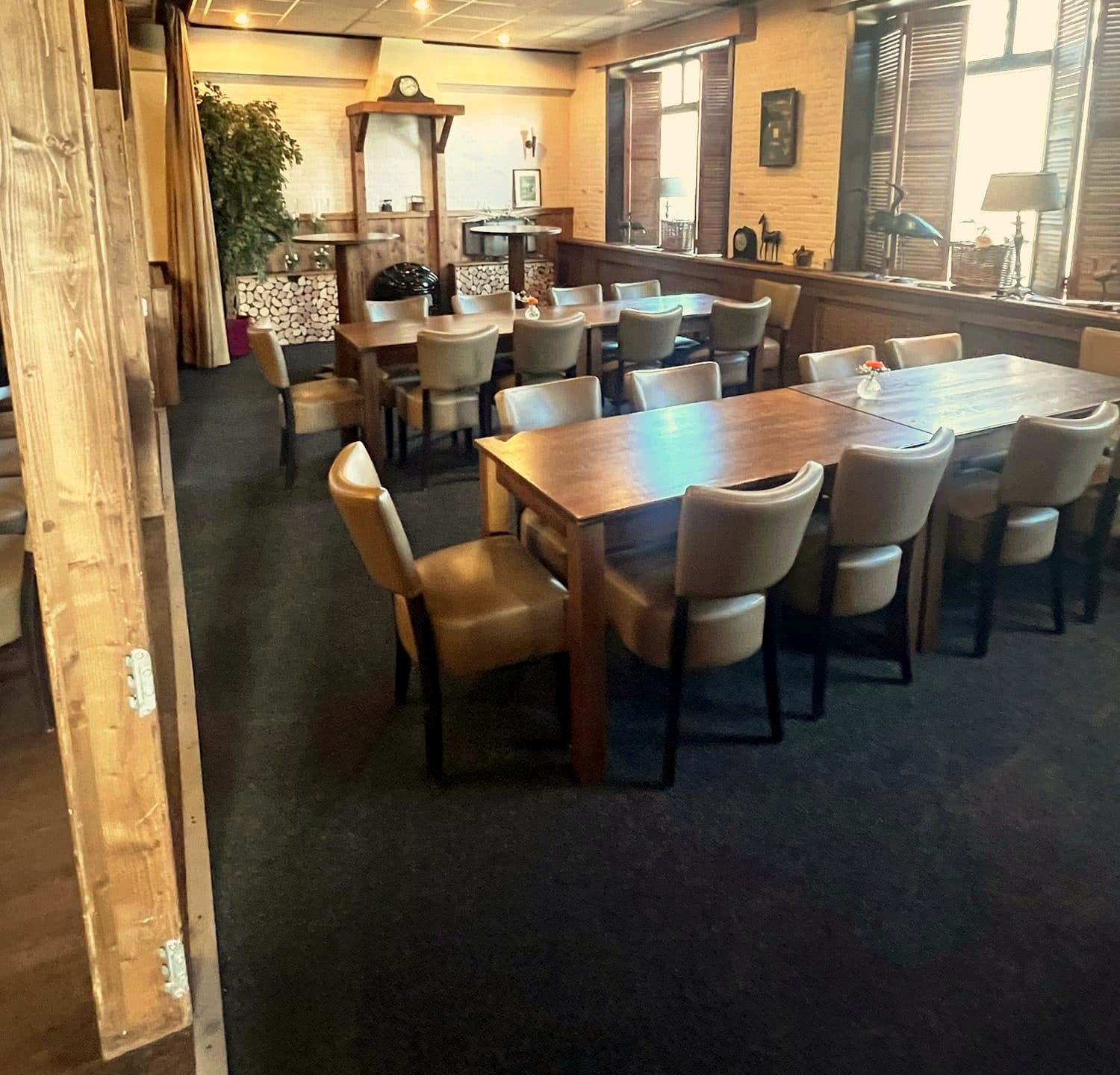 Deel van de grote zaal met tafels bij de raampartij