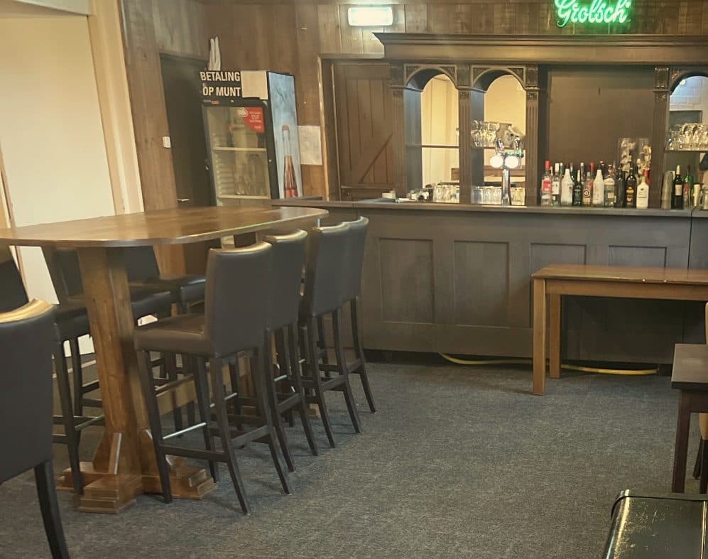 De bar van de kleine zaal met statafel en barkrukken